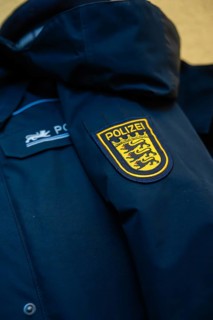 Close-up of a police jacket with a prominent badge on the sleeve