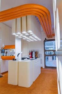 Contemporary kitchen with eye-catching white lighting and orange decoration