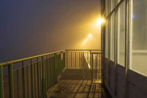 View along a balcony of Steubenhöft at night in fog, Cuxhaven, Lower Saxony, Germany