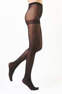 Barefoot female legs in dense black tights walking on tiptoes over white background