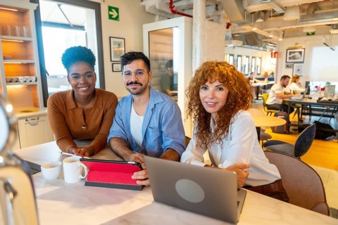 Diverse team of business professionals smiling while working together on projects and having a