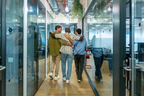 Diverse business colleagues walking together down a modern office corridor, reflecting teamwork,
