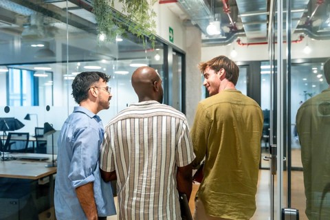 Three diverse men colleagues are engaging in conversation, networking, and discussing ideas while