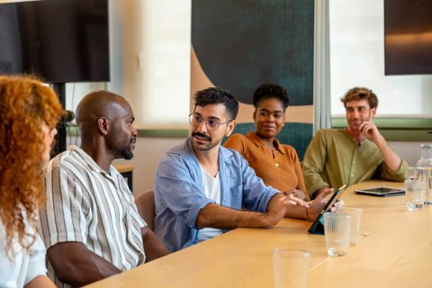 Diverse group of colleagues meeting in a modern office, collaborating and discussing ideas during a
