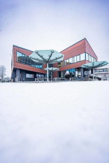Modern town hall, predominantly glazed building in snowy, wintry surroundings, Gechingen, Calw