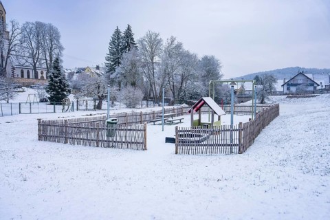 A snowy playground in a small village surrounded by trees, Gechingen, Calw district, Germany