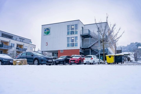 Snowy modern building with parked cars in the foreground in winter, Gechingen retirement home, Calw