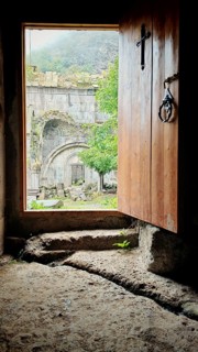 An open entrance to a monastery with a view of the old stone structure in the courtyard, Debed