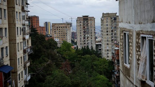 Old high-rise buildings with views of the city and surrounding trees, nostalgic curtain blowing