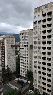 Three high-rise buildings connected by metal bridges under cloudy skies, nostalgic charm,