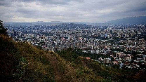 Hiking trail and view from a hill over a vast urban landscape, Tbilisi, Georgia