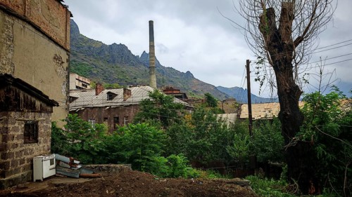 Old factory, ruins of buildings surrounded by mountains and dense vegetation, Armenia