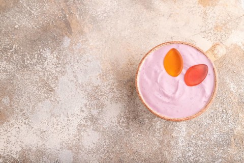 Purple Yogurt, with jelly candy on brown concrete background, top view, flat lay, copy space,