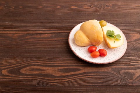Smoked Mozzarella cheese, with tomatoes and olives on brown wooden background, side view, copy