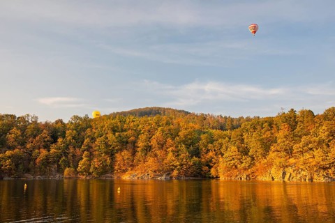 Hot air balloons over the Brno Reservoir (Brnenská prehrada) on the Svratka River on a sunny autumn