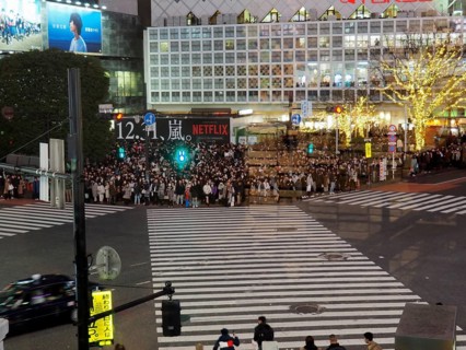 Crowds of people at night at a busy urban crossroads, Shibuya, Tokyo, Japan