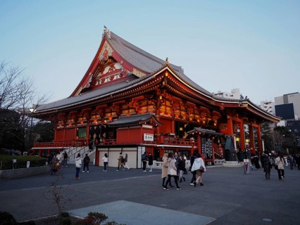 Large illuminated temple with people in front of it in the evening, Sensoji Temple, Tokyo, Japan