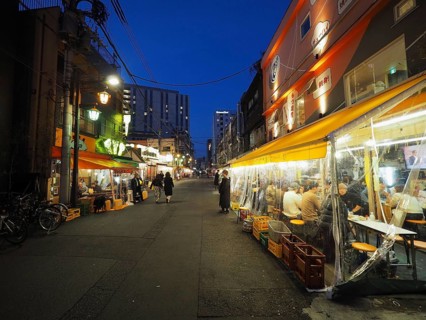 Narrow street at night with brightly lit restaurants and relaxed atmosphere, Nishi-Asakusa, Tokyo,