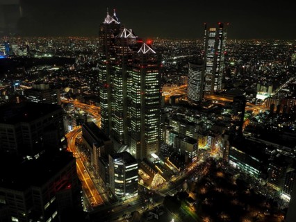 Night scene of an impressive cityscape with illuminated skyscrapers and bustling streets, Tokyo,