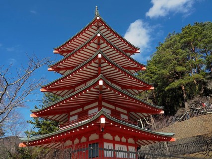 Chureito pagoda against blue sky surrounded by green trees, Kawaguchiko, Japan