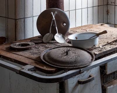 Rusted stove with kitchen appliances in the kitchen in an abandoned country inn, Lost Place,