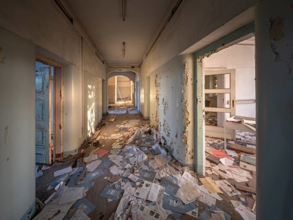 A room and corridor full of files lying around in an abandoned administration building, Lost Place,