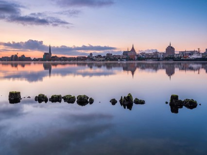 Old town and city port are reflected in the Warnow river, morning scene, Rostock,