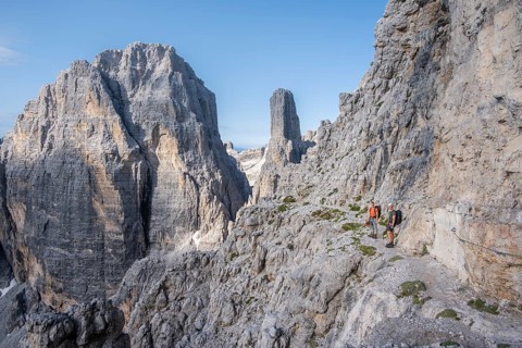 Climbers on a rock band, Bocchette Centrale band trail, via ferrata in the Brenta Mountains,