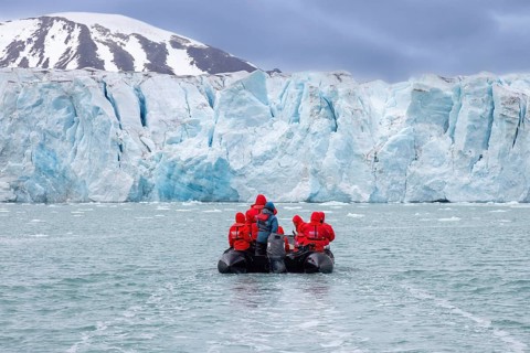 Boat with eco-tourists in front of Idabreen, Ida glacier calving into Liefdefjorden at Idabukta