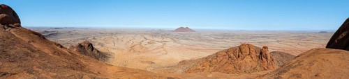 Panoramic picture of dry, rocky desert landscape under blue sky, Spitzkoppe, Namibia