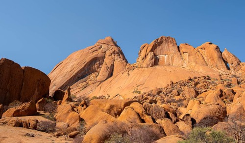 Monumental sandstone mountains rise into the clear desert sky, Spitzkoppe, Namibia