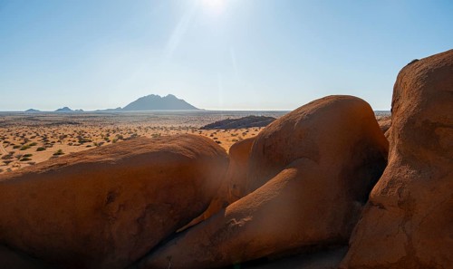 Sunny desert landscape with view of distant mountain range, Spitzkoppe, Namibia
