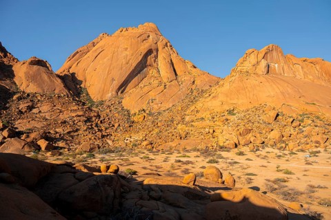 Wide view of impressive rocky mountains under a cloudless sky in Spitzkoppe, Spitzkoppe, Namibia