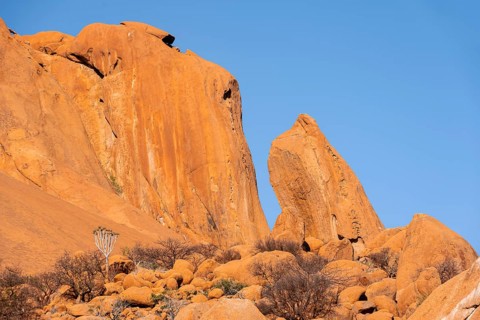 Impressive orange cliffs under a clear sky in the Spitzkoppe desert, Spitzkoppe, Namibia