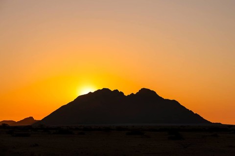 Sunset behind a distinctive mountain silhouette in the wilderness of Spitzkoppe, Spitzkoppe,
