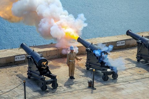 Soldier firing cannon salute with SBBL 32-pounder gun at 16th century Saluting Battery at Grand