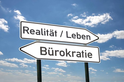 (photo montage) Directional arrows against a blue sky with the inscription REALITY/LIFE and