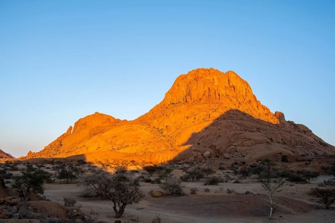 Rocks at sunset in the Namibian desert glow intensely orange, Spitzkoppe, Namibia