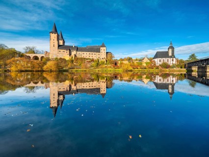 Rochlitz Castle and St. Peter's Church in autumn, perfect reflection in the Zwickauer Mulde river,