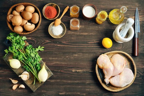 Top view of food ingredients for cooking including chicken meat, vegetables, spices and herbs