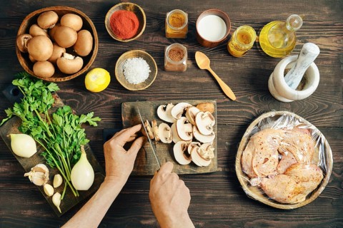 High angle view of person cutting mushroom for a meal. Lifestyle food preparation with wrapped