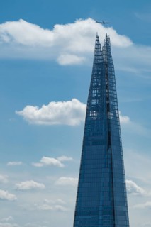 View from the Sky Garden of the modern glass skyscraper The Shard over which an airplane flies,