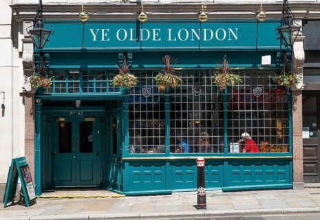 Traditional London pub Ye Old London with green façade and hanging flowers, London, England, Great