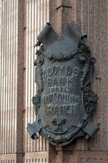 Lloyds Bank coat of arms like metal sign in decorative style on stone wall, London, England, Great