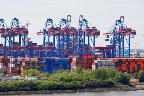 Containers are stored at the Burchardkai loading terminal with cranes on the Elbe in the Port of