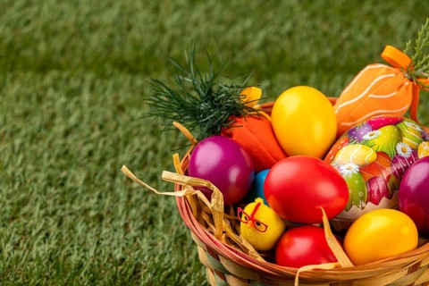 A basket of colorful Easter eggs in a meadow