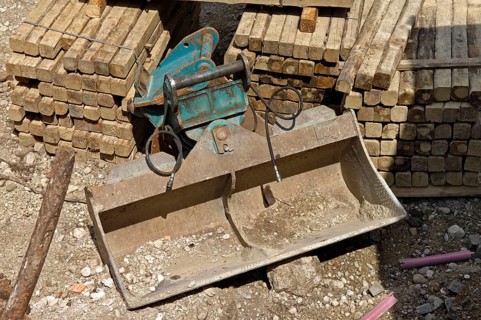Wooden beam and shovel of an excavator on a construction site