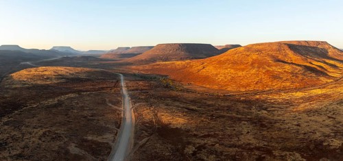 Aerial view, road leading through dry desert landscape, hills in Damaraland, Namibia