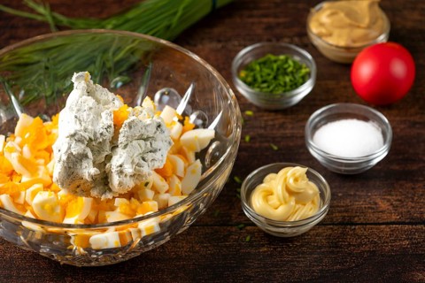 Cream cheese and ingredients for egg cream placed in a bowl