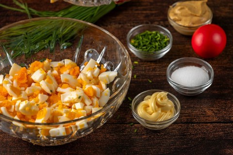 Ingredients arranged in trays for egg cream on a wooden table